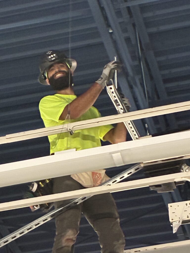 Steel City electrician installing overhead strut on a lift at IKEA Sarasota