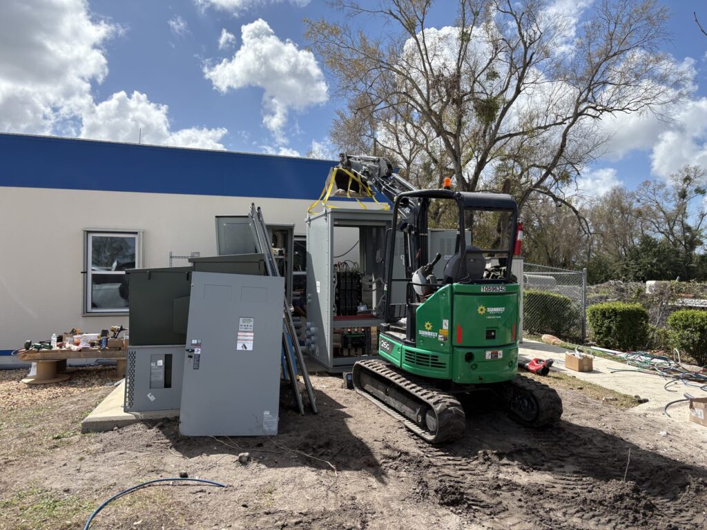 Excavator and switchgear during a new electrical service installation in Tampa